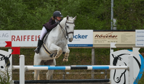 Tjej som hoppar hinder på häst