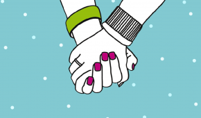 Två händer som håller i varandra när det snöar