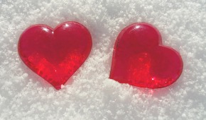 Två röda glashjärtan i snön